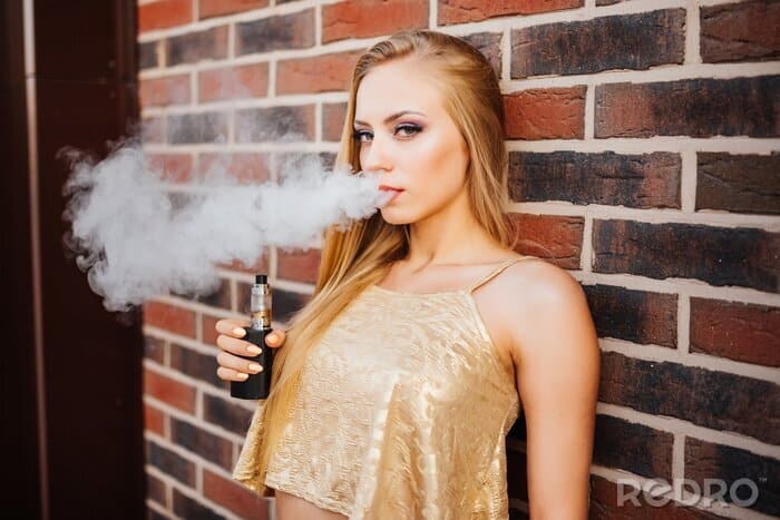elegancka kobieta wapująca, stylowy e-papieros damski, modne akcesoria vape, kobieca dłoń trzymająca vape - Obraz Vaping. Młoda piękna dziewczyna palenia (vaping) e-papieros ...