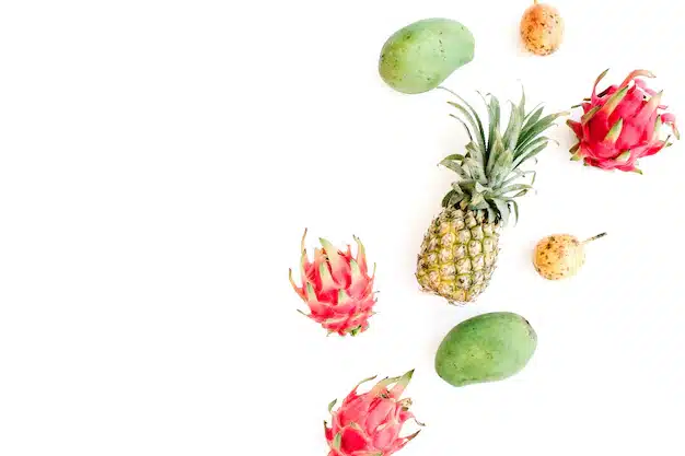 Kosz pełen świeżych, soczystych owoców tropikalnych takich jak mango, ananas, marakuja i gujawa, leżący na tle egzotycznej plaży lub liści palmowych.
